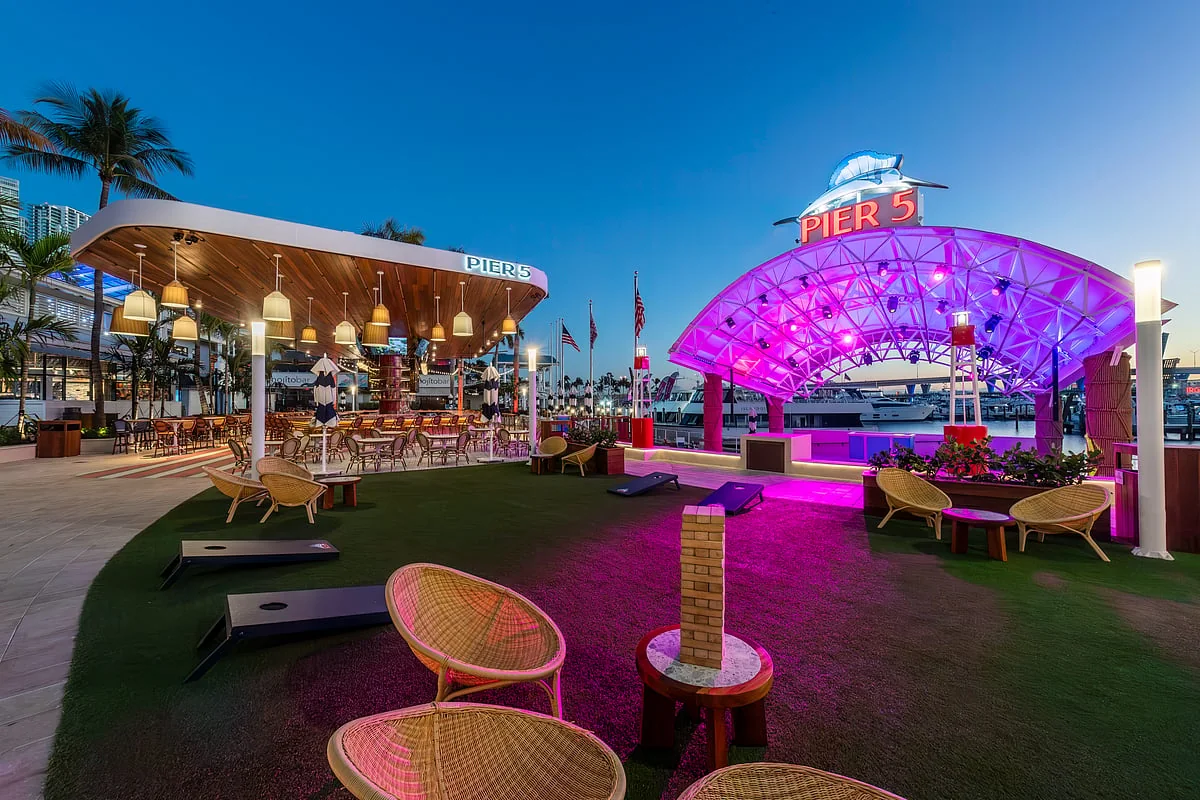 Pier 5 at dusk, with its illuminated waterfront stage, outdoor seating and Rum Bar at Bayside Marketplace in Miami