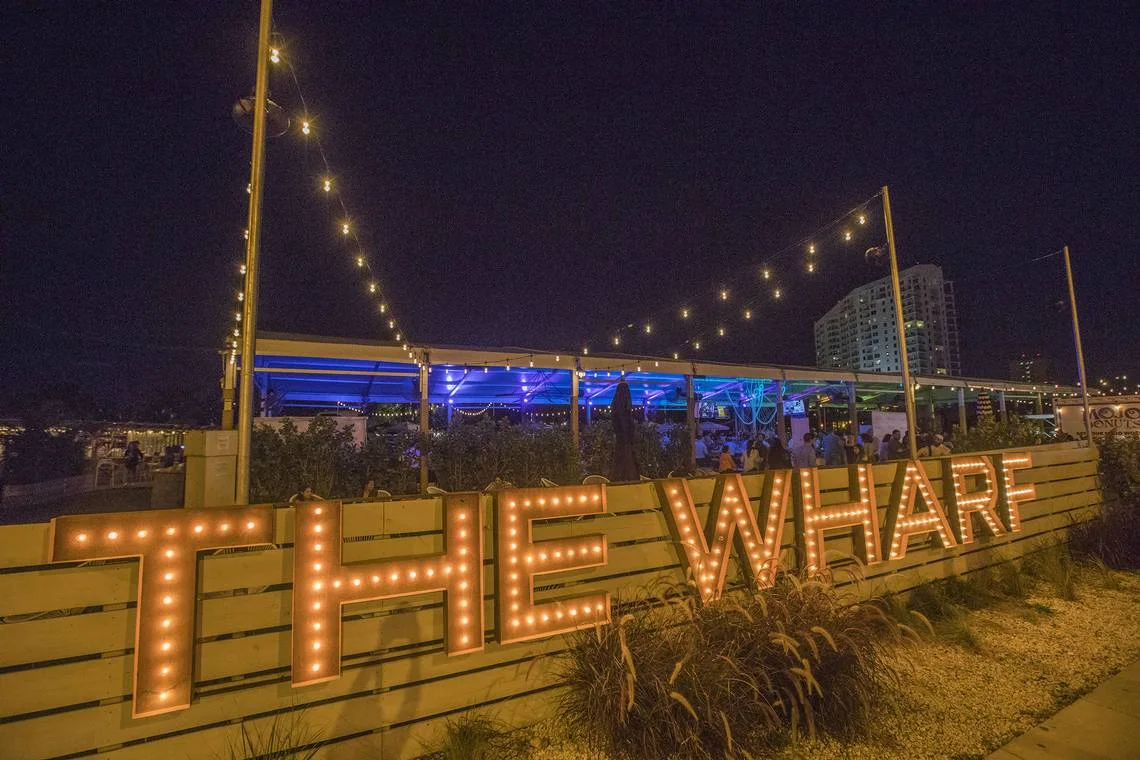 The Wharf Miami — illuminated venue sign and evening setting
